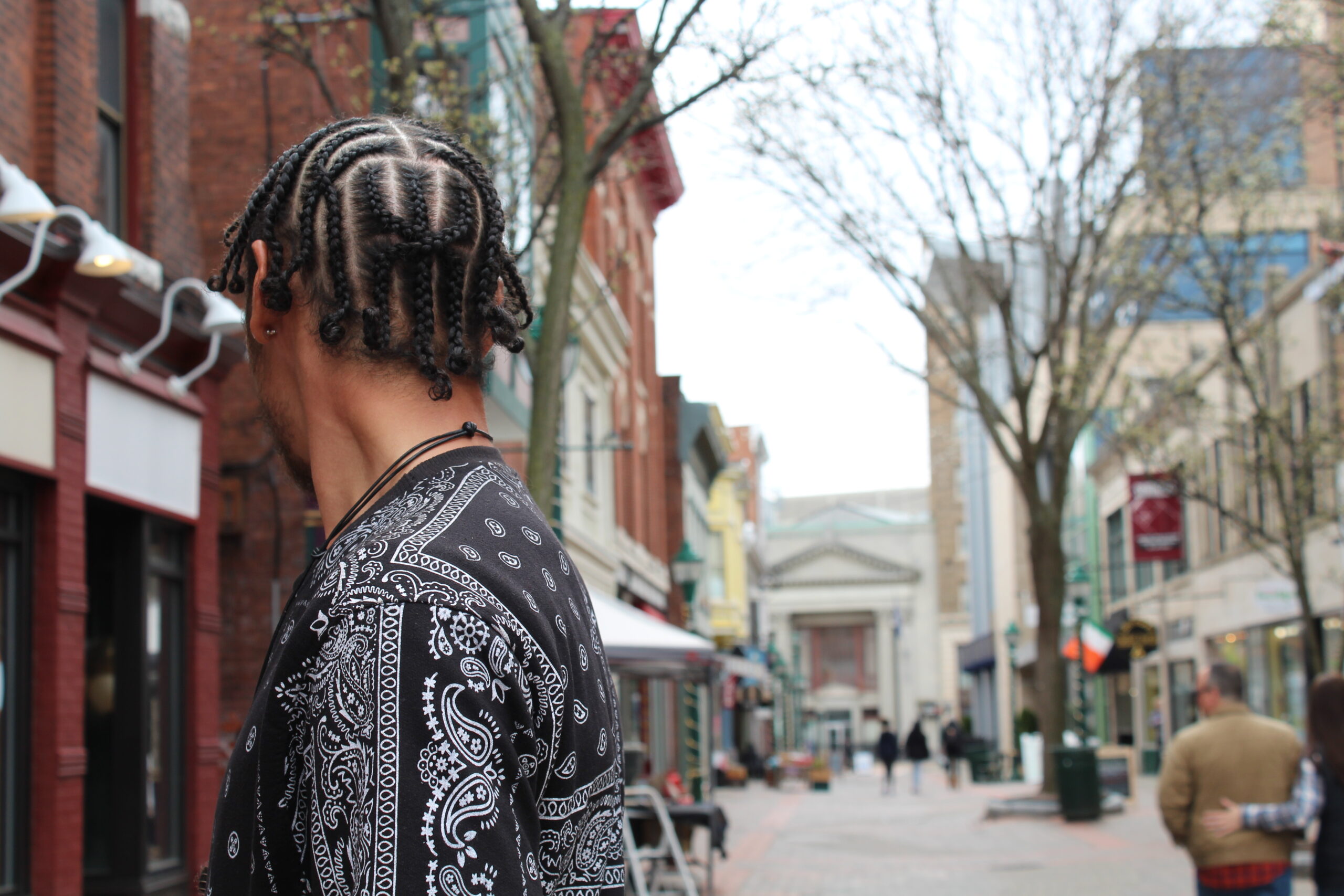 a man looks away fom the camera showing off his braids
