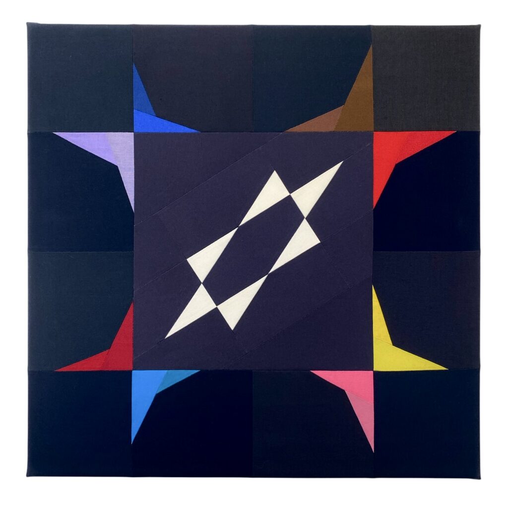 A quilted image with a central six pointed star on a dark blue background, surrounded by 4 geometric arrangements, which together resemble butterflies.